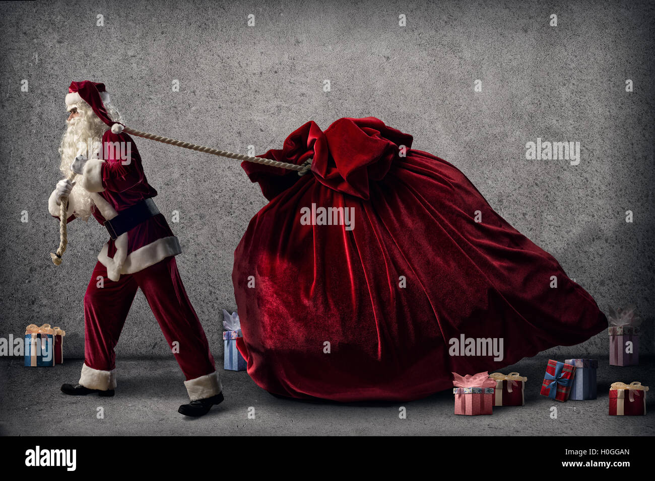 Santa Claus pulls a huge bag of gifts Stock Photo - Alamy