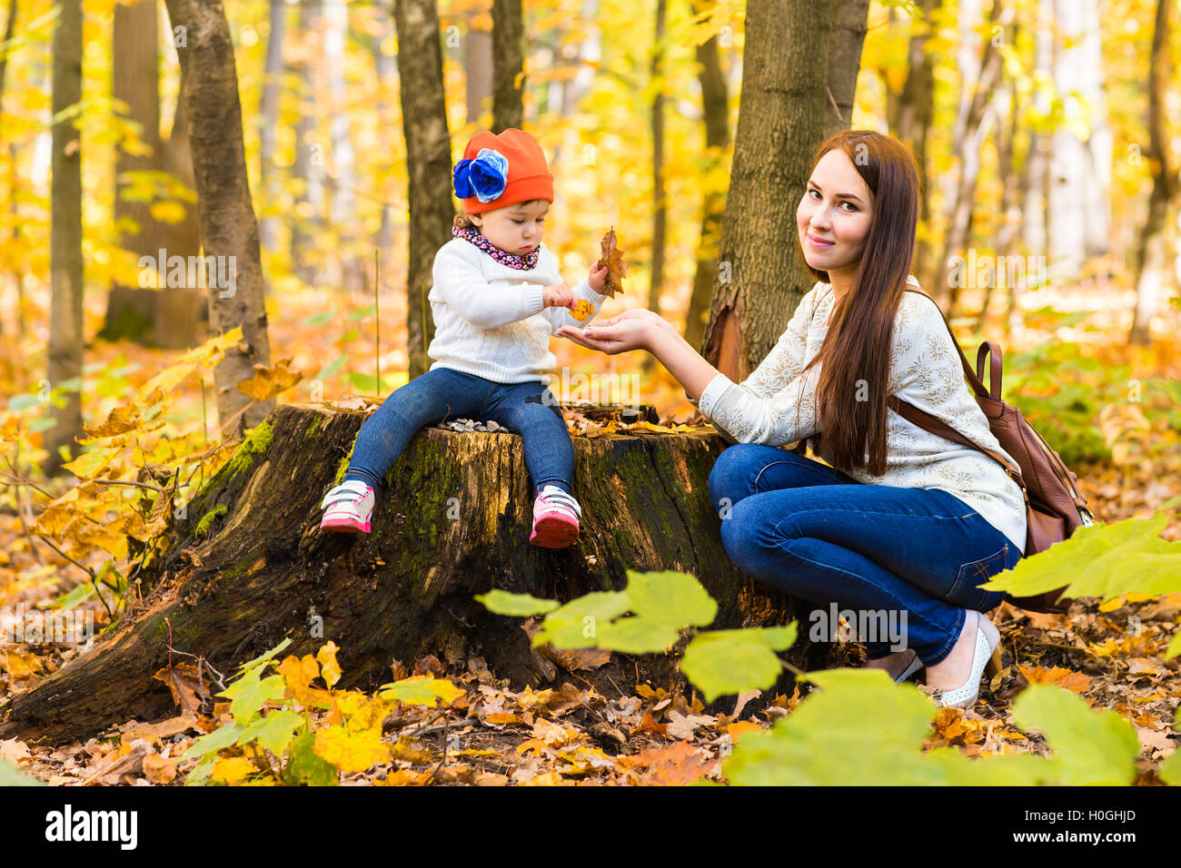 Little girl and her mother playing in the autumn park Stock Photo - Alamy