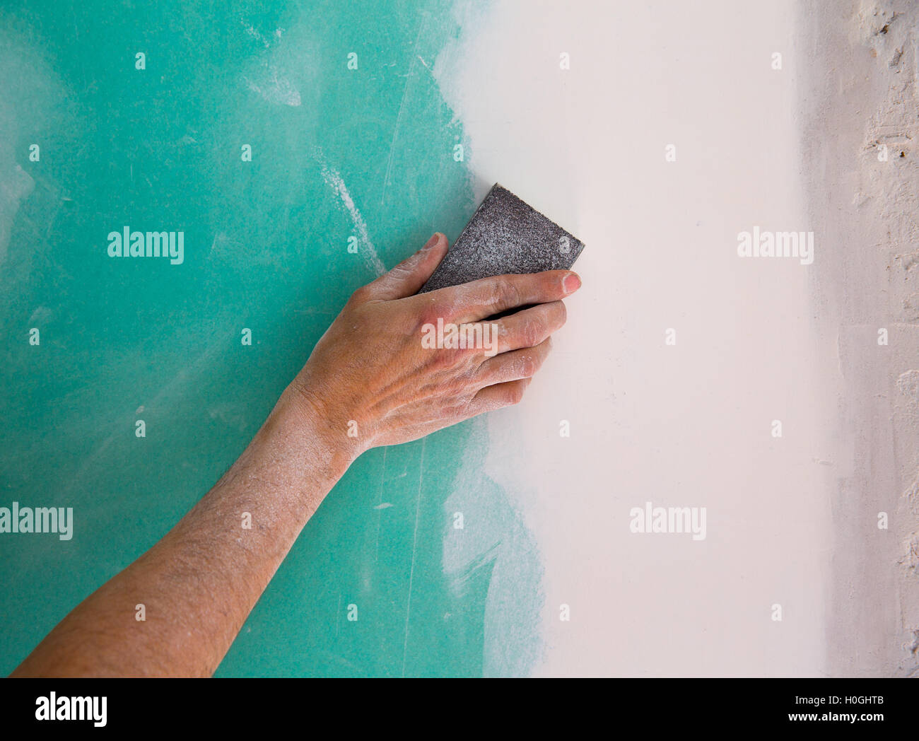 plastering man hand sanding the plaste in drywall seam Stock Photo Alamy