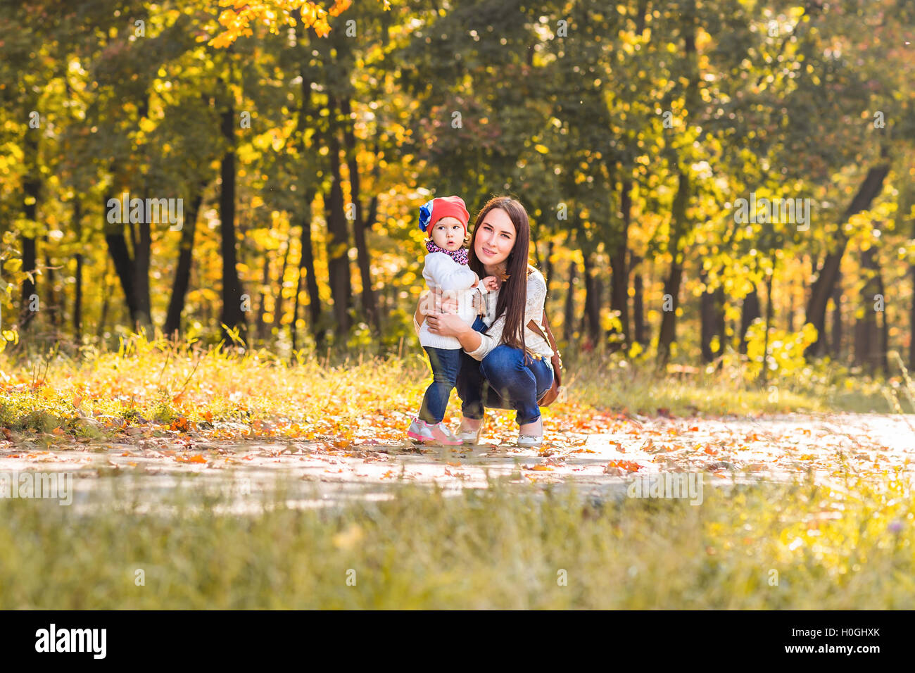 Little girl and her mother playing in the autumn park Stock Photo - Alamy