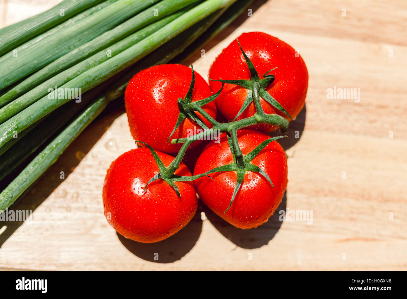 Fresh juicy tomatoes on wooden chopping board Stock Photo - Alamy