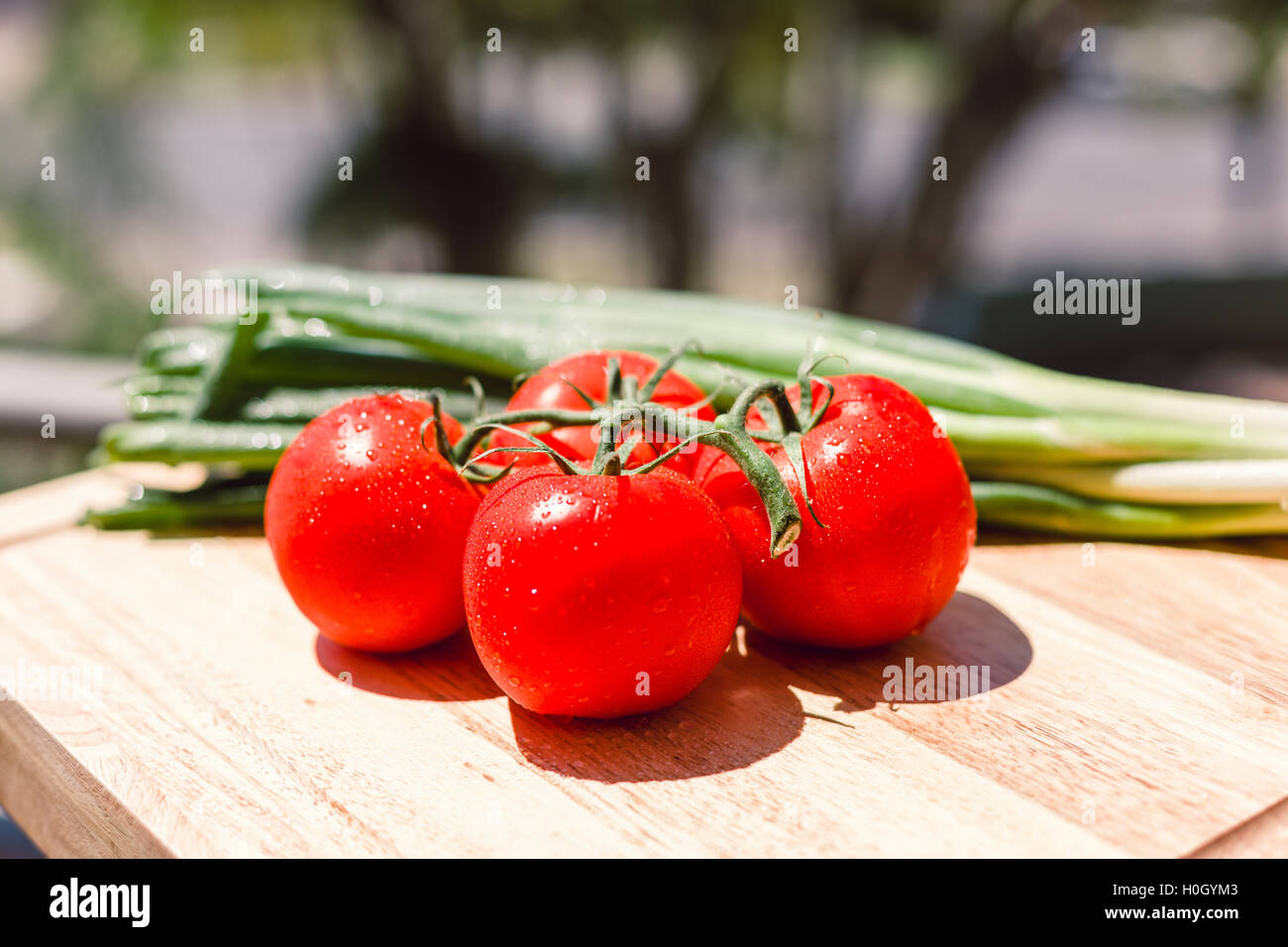 Fresh juicy tomatoes on wooden chopping board Stock Photo - Alamy