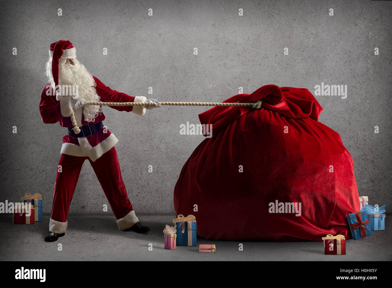 Santa Claus pulls a huge bag of gifts Stock Photo - Alamy