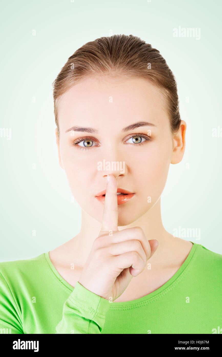 Teen girl with finger on her lips Stock Photo - Alamy