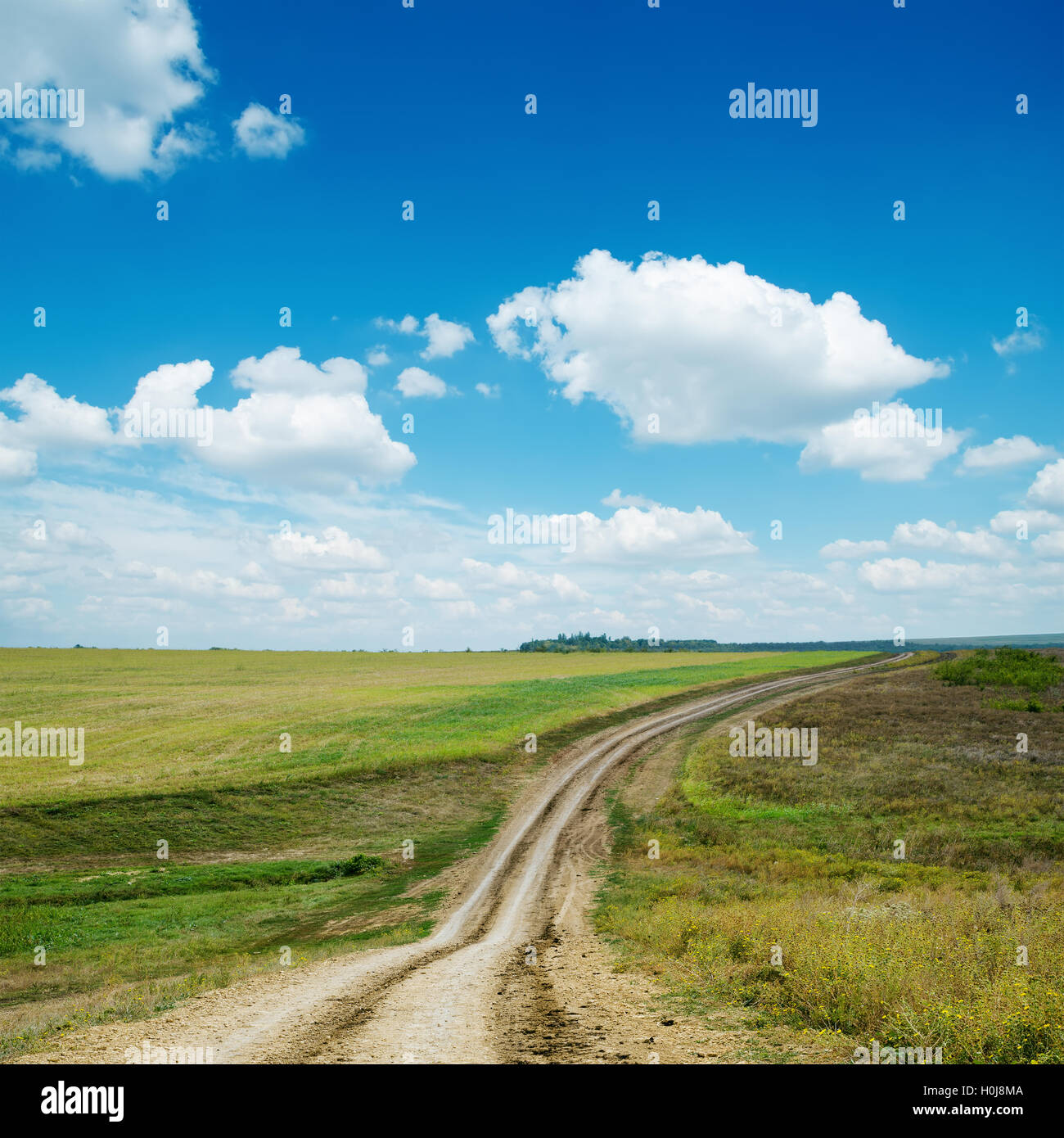 dirty road and blue sky with clouds Stock Photo - Alamy
