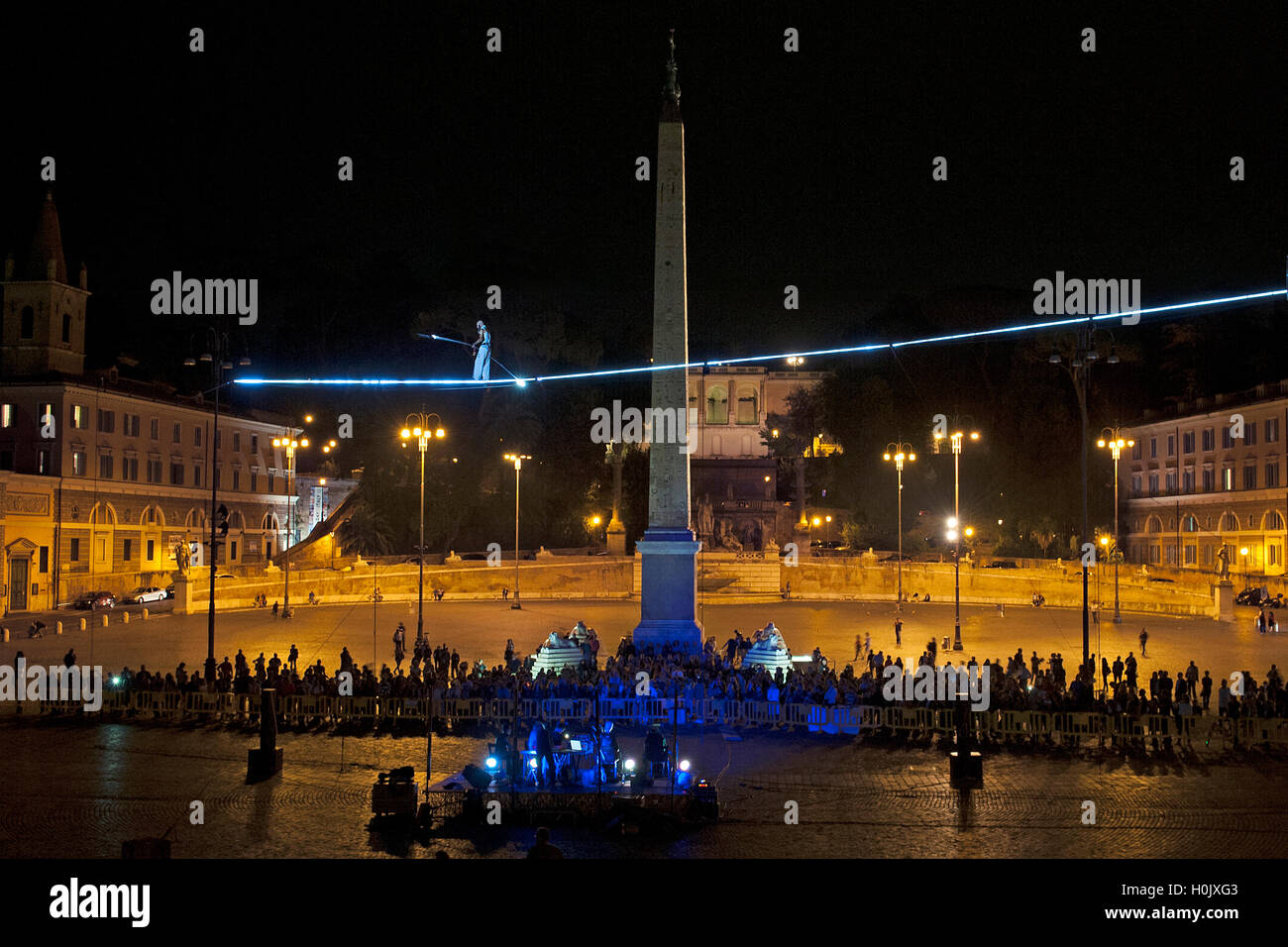 The acrobat Andrea Loren walking crosses on a wire at night Piazza del ...