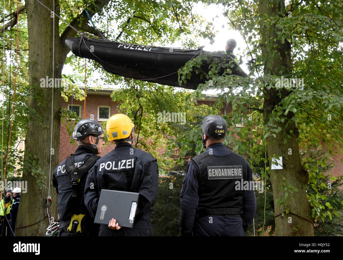 Kiel, Germany. 21st Sep, 2016. German federal police officers and French gendarmes stand in front of a rubber raft hanging between trees with demonstrator impersonators during a drill in Kiel, Germany, 21 September 2016. Federal police specialists from all over Germany and French police officers are practicing the retrieval of so-called 'disturbers' that have chained themselves to trees and buildings. Photo: CARSTEN REHDER/dpa/Alamy Live News Stock Photo