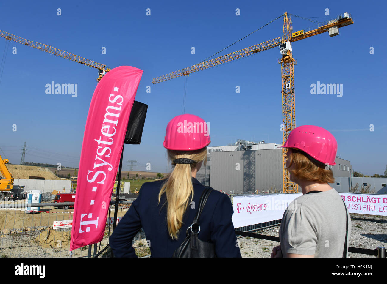 Biere, Germany. 12th Sep, 2016. Women wear protection helmets in the colour magenta, the logo colour of Deutsche Telekom, at the laying of the first stone for the expansion of the Cloud-Rechenzentrum of Deutsche Telekom in Biere, Germany, 12 September 2016. Photo: Jens Kalaene/dpa/Alamy Live News Stock Photo