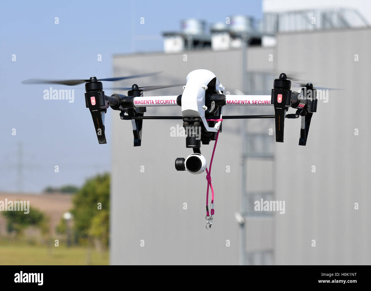 Biere, Germany. 12th Sep, 2016. A drone of Telekom with the inscription 'Magneta Telekom' flies across the grounds at the laying of the first stone for the expansion of the Cloud-Rechenzentrum of Deutsche Telekom in Biere, Germany, 12 September 2016. Photo: Jens Kalaene/dpa/Alamy Live News Stock Photo