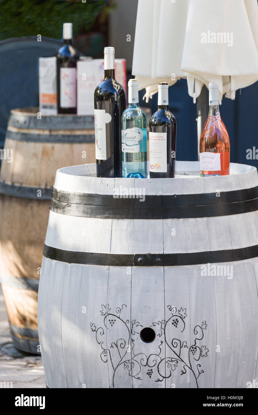 Wine bottles on barrel in street, Lourmarin, Luberon, Provence, France Stock Photo