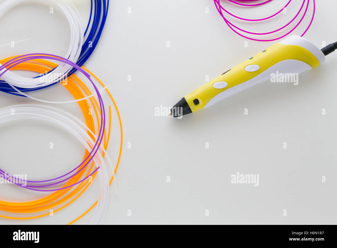 3D pen and colourful filaments and white background. Top view. Copy space for text. Technology, creativity, leisure concept Stock Photo