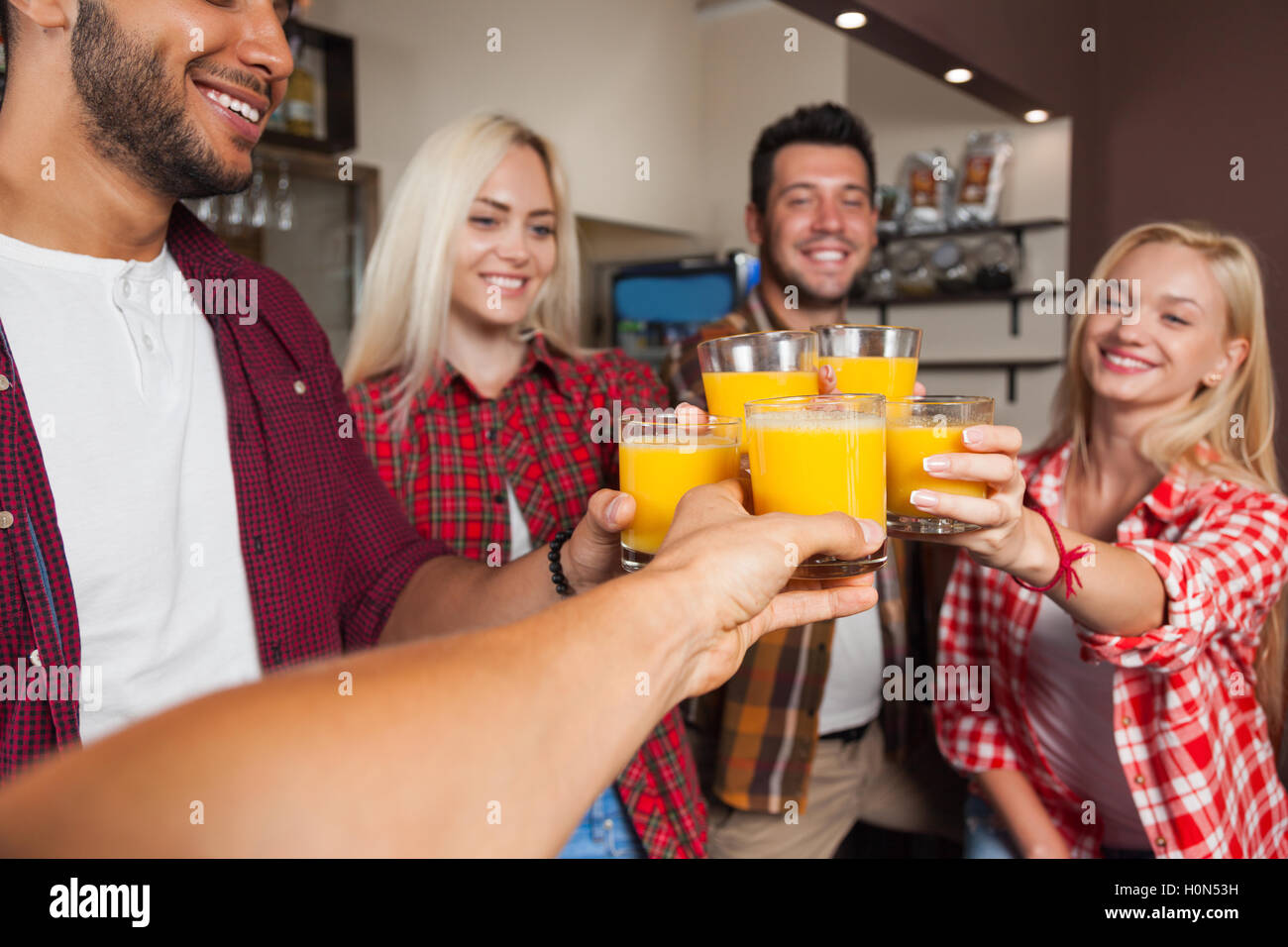 People Friends Drinking Orange Juice, Toasting At Bar Counter, Mix Race Man And Woman Cheers