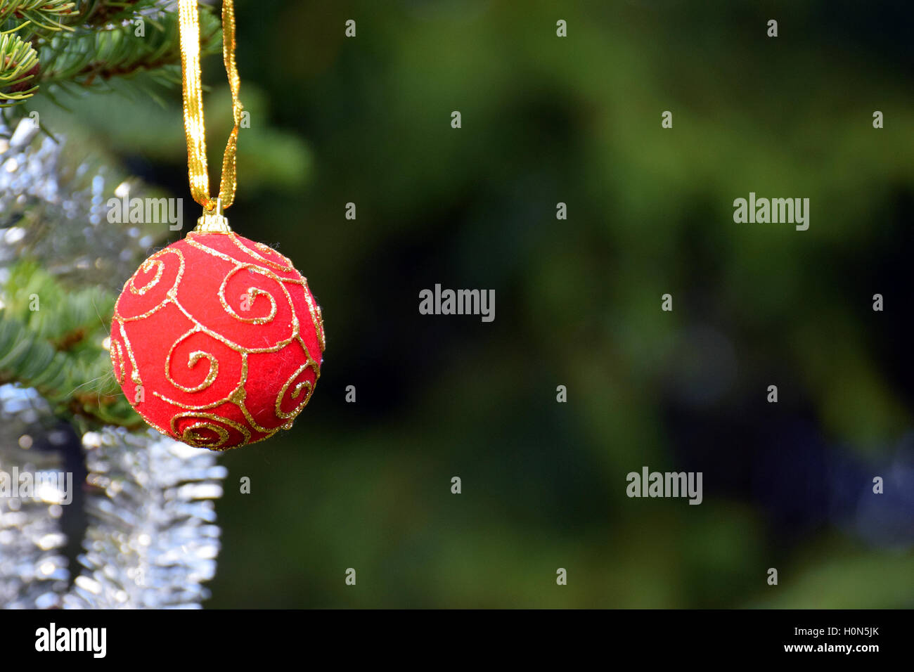 Christmas time. Hanging Christmas ball with green background. Stock Photo