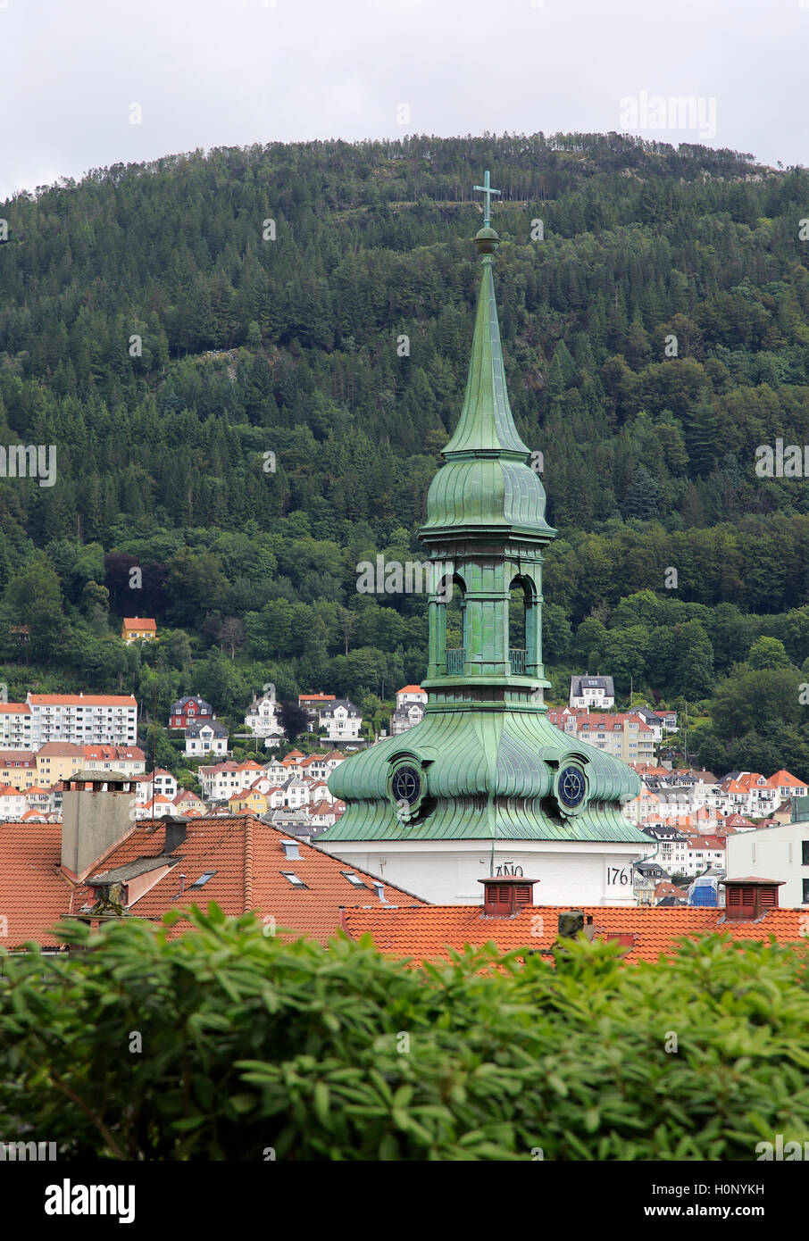 Spire of historic Nykirken church towering over rooftops city of Bergen ...