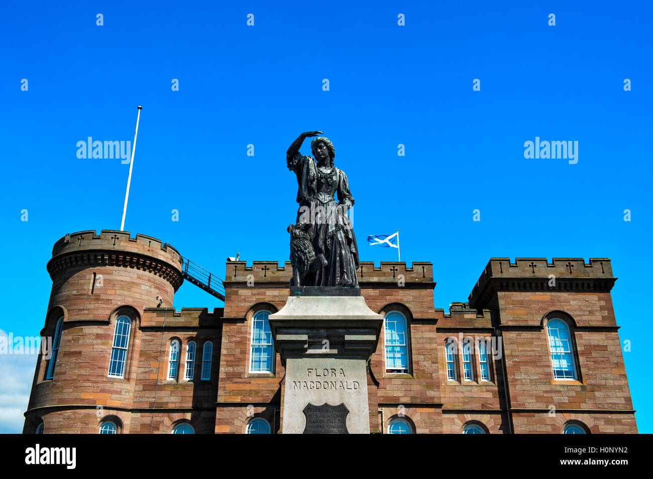 Bronze-Denkmal von Flora MacDonald vor dem Schloss Inverness mit der schottischen Flagge, Inverness, Schottland, Grossbritannien Stock Photo