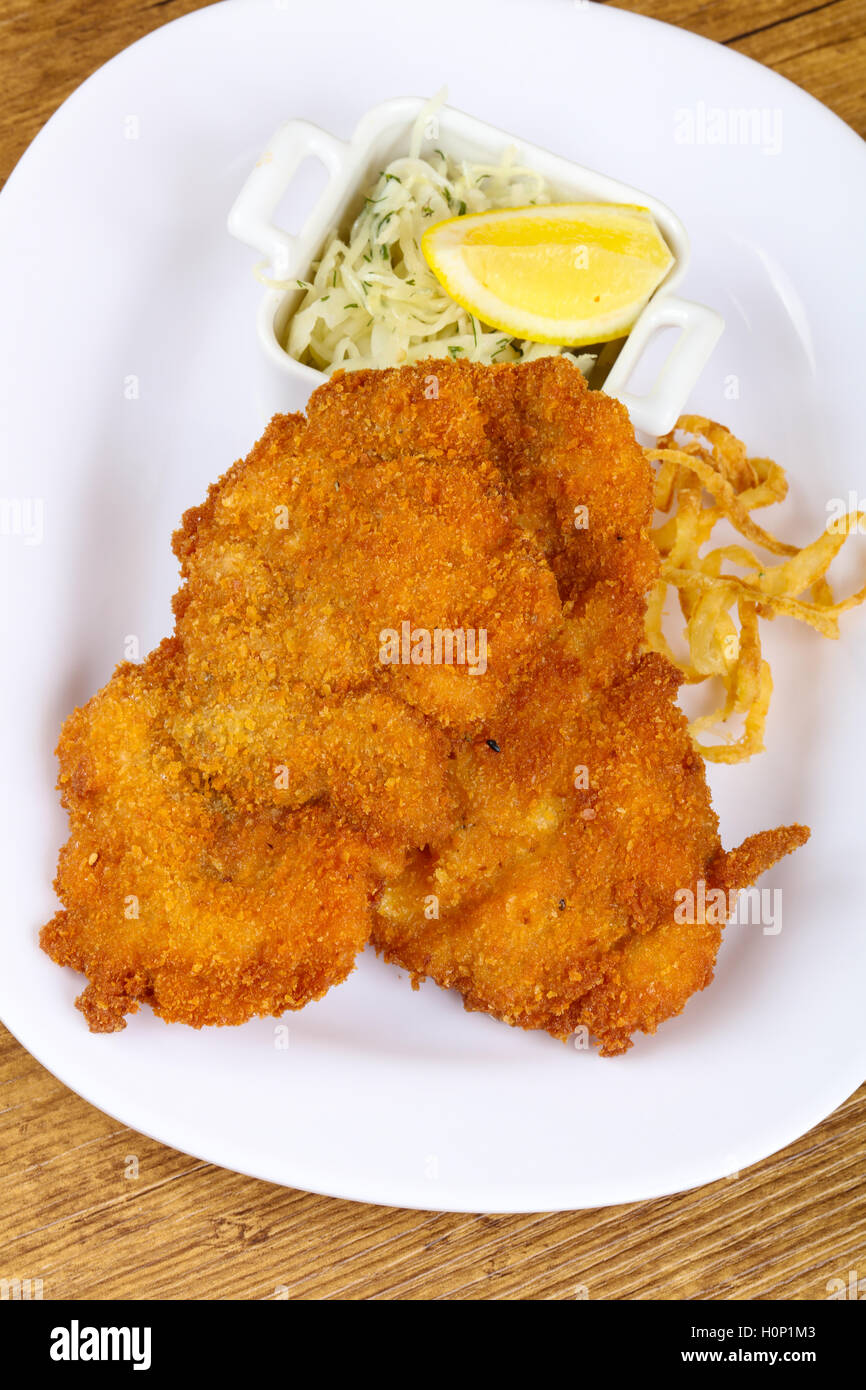 Czech cuisine - schnitzel with cabbage and lemon Stock Photo - Alamy