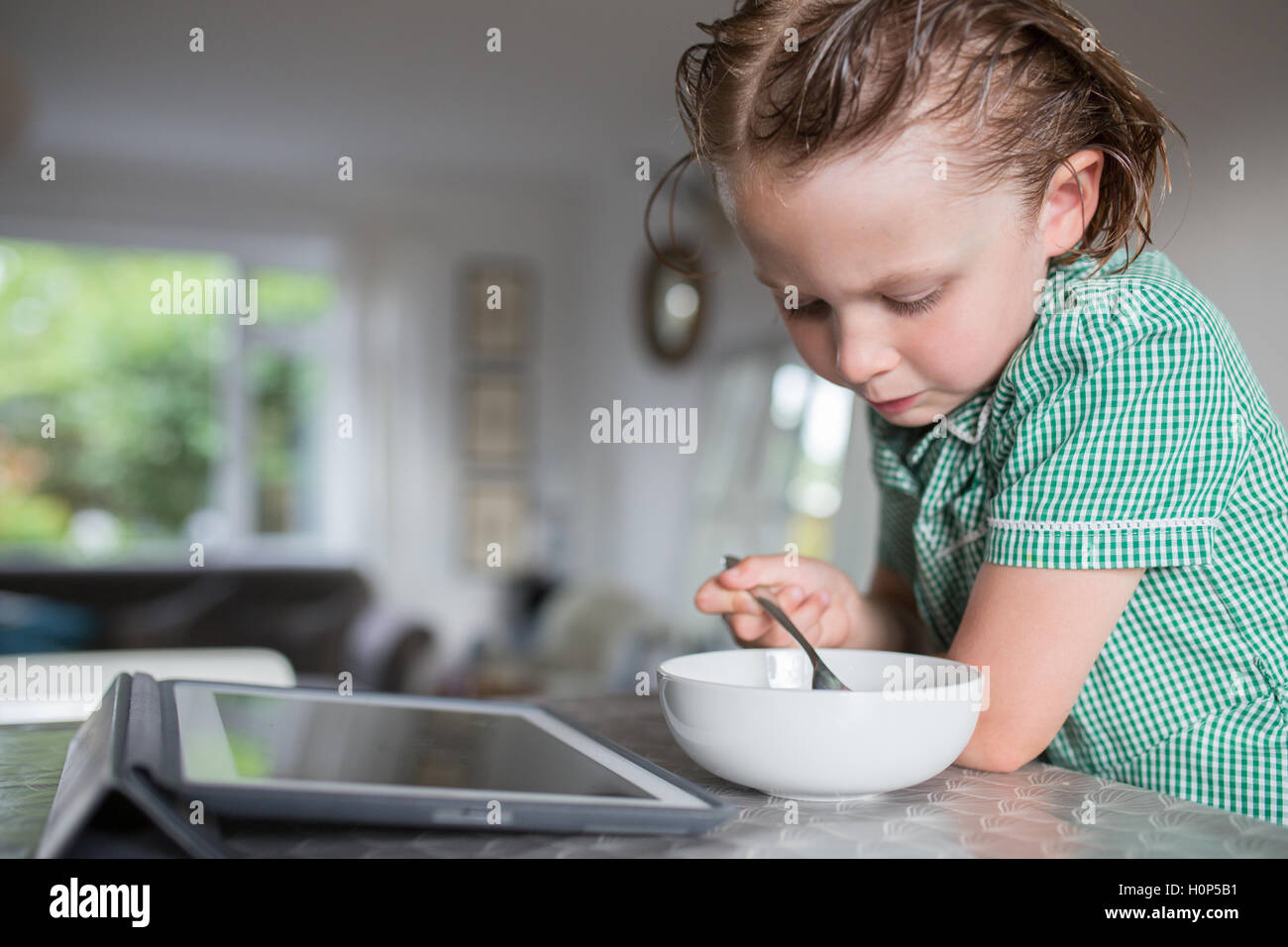 girl eating breakfast while watching the ipad Stock Photo Alamy