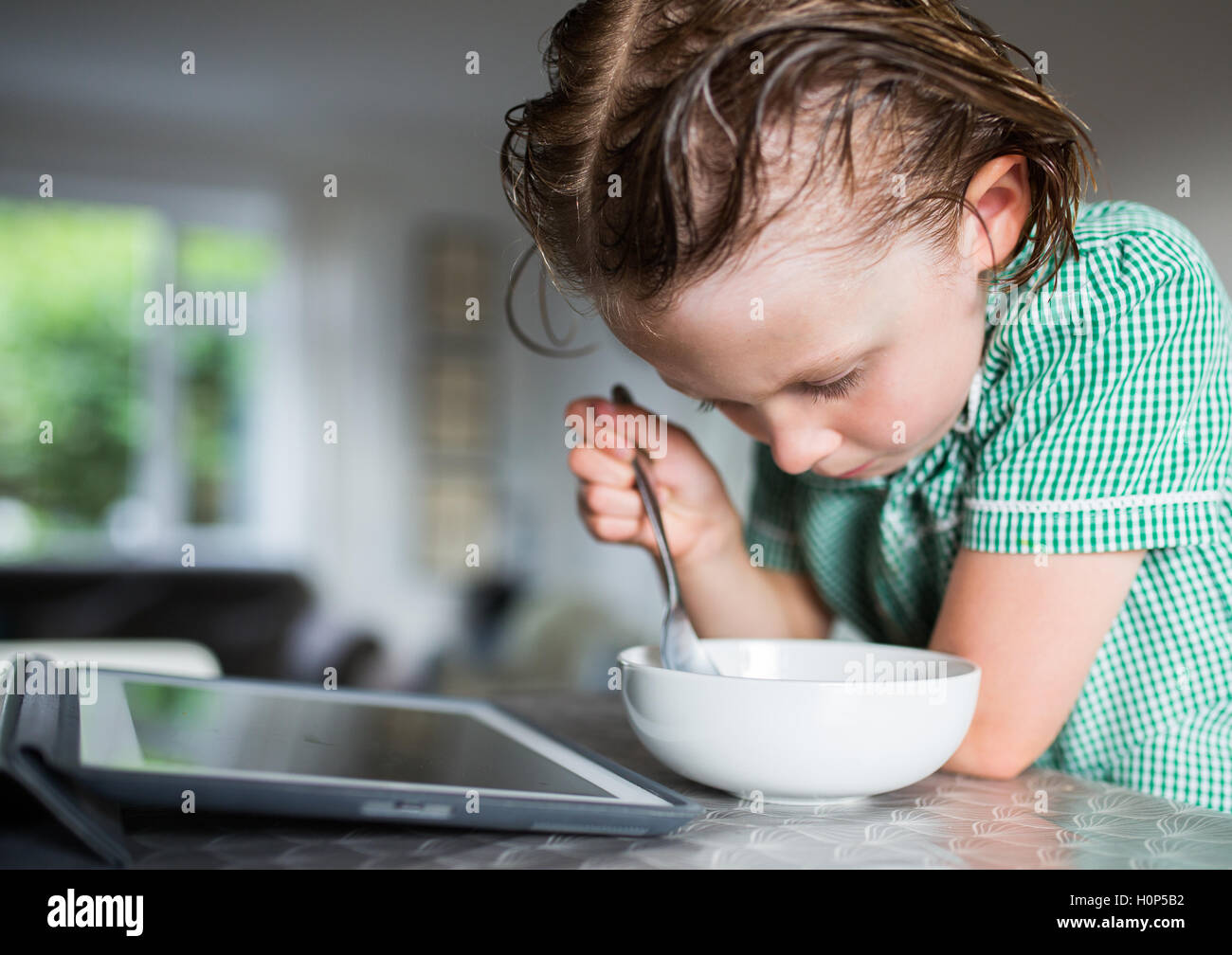 girl eating breakfast while watching the ipad Stock Photo Alamy