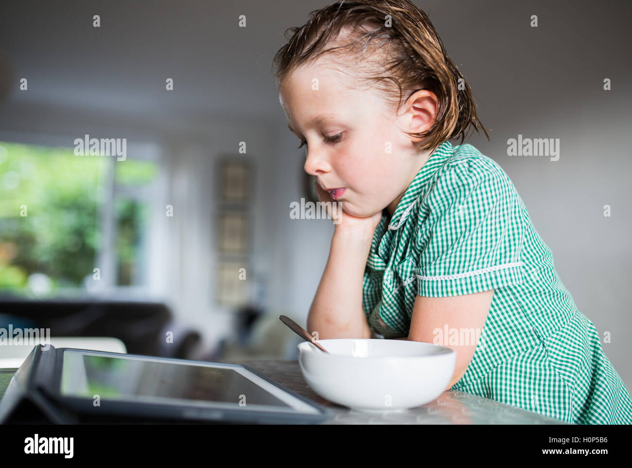 girl eating breakfast while watching the ipad Stock Photo Alamy