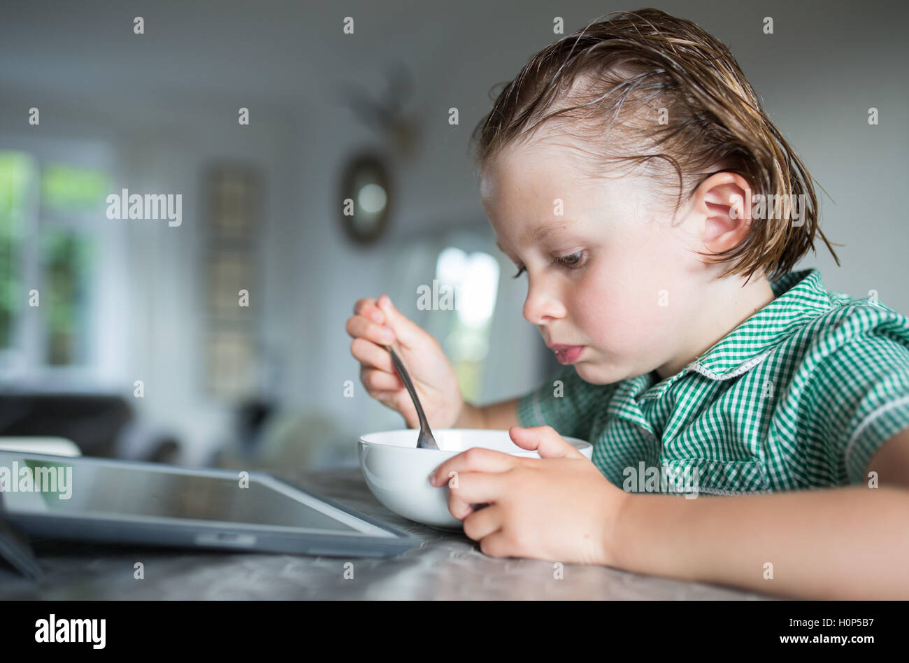 girl eating breakfast while watching the ipad Stock Photo Alamy