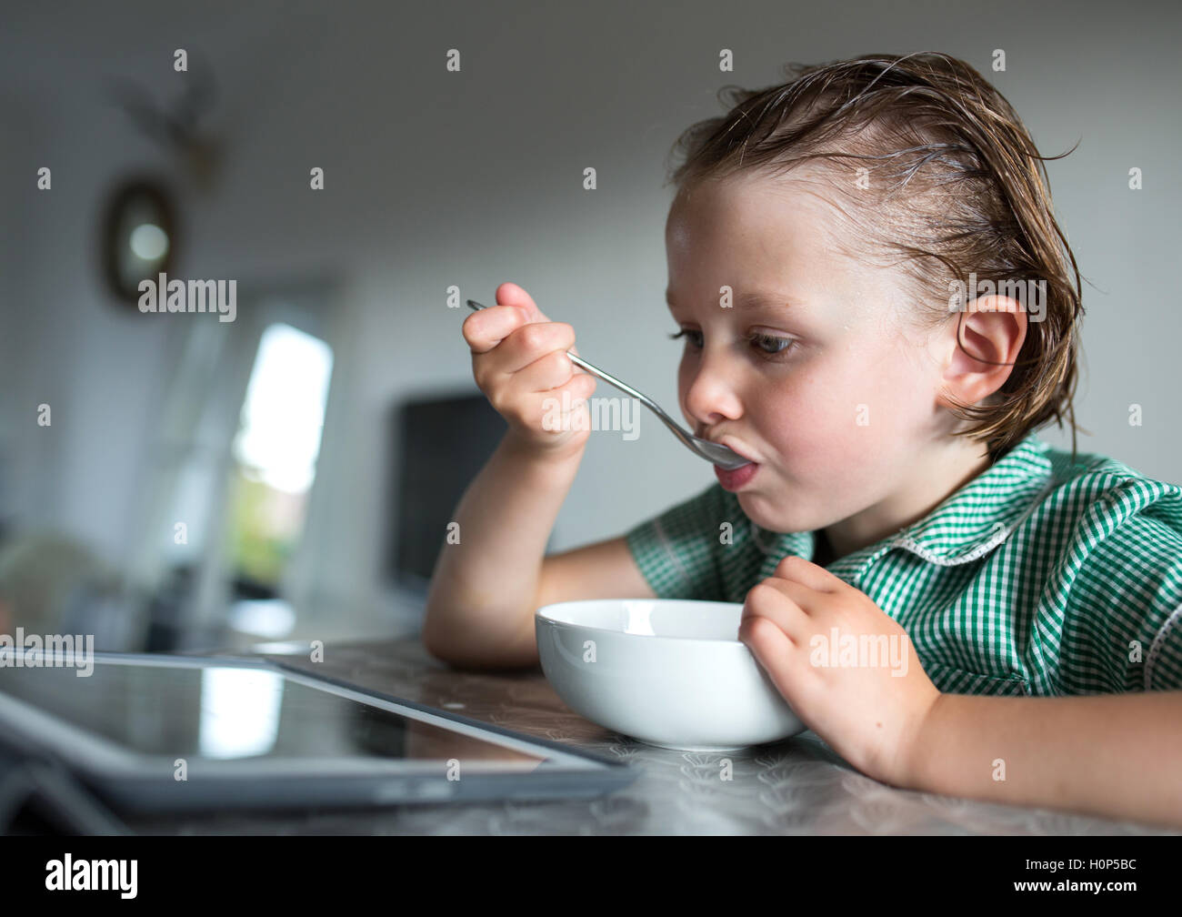 girl eating breakfast while watching the ipad Stock Photo Alamy