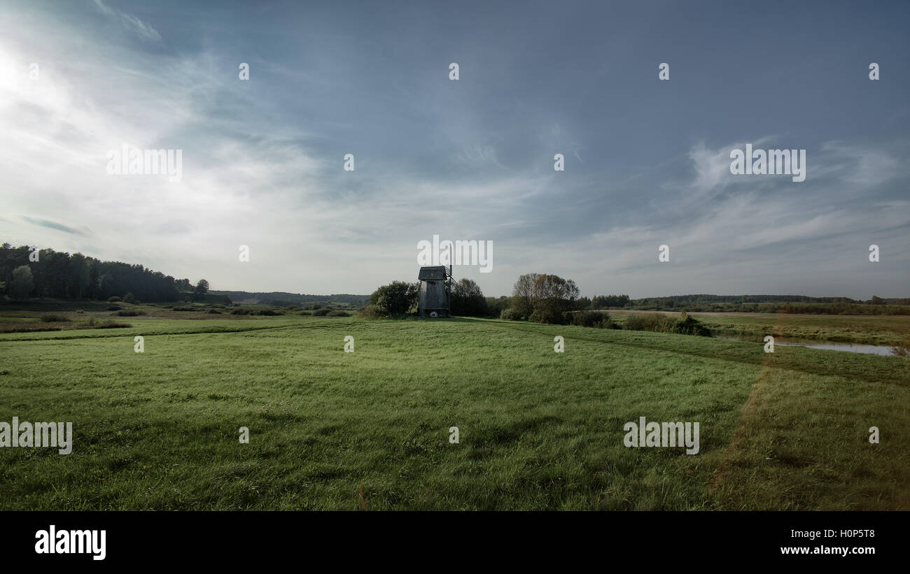 windmill in the green field on blue sky background with white clouds Stock Photo