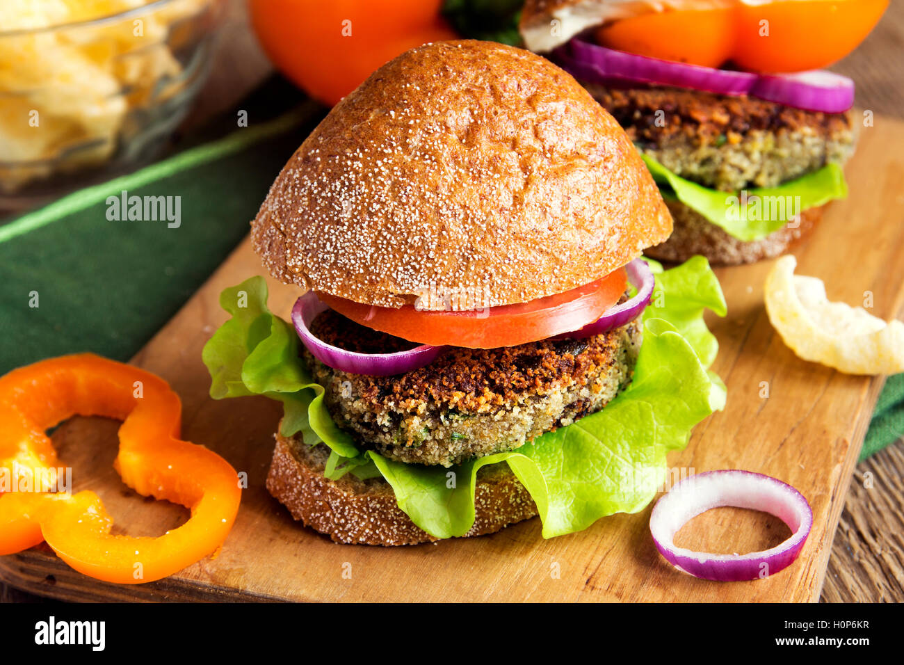 Vegetarian lentil burger with vegetables on wooden cutting board - healthy tasty vegetarian snack (food, lunch) Stock Photo