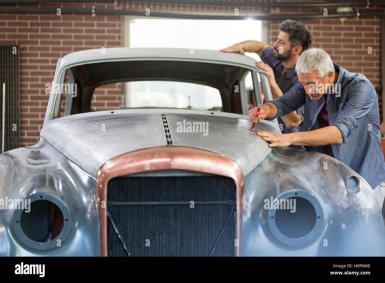 mechanic rebuilding classic car auto body shop Stock Photo - Alamy