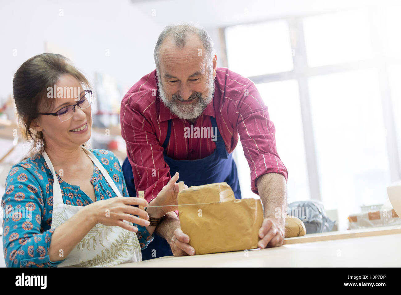 couple cutting block clay pottery studio Stock Photo Alamy