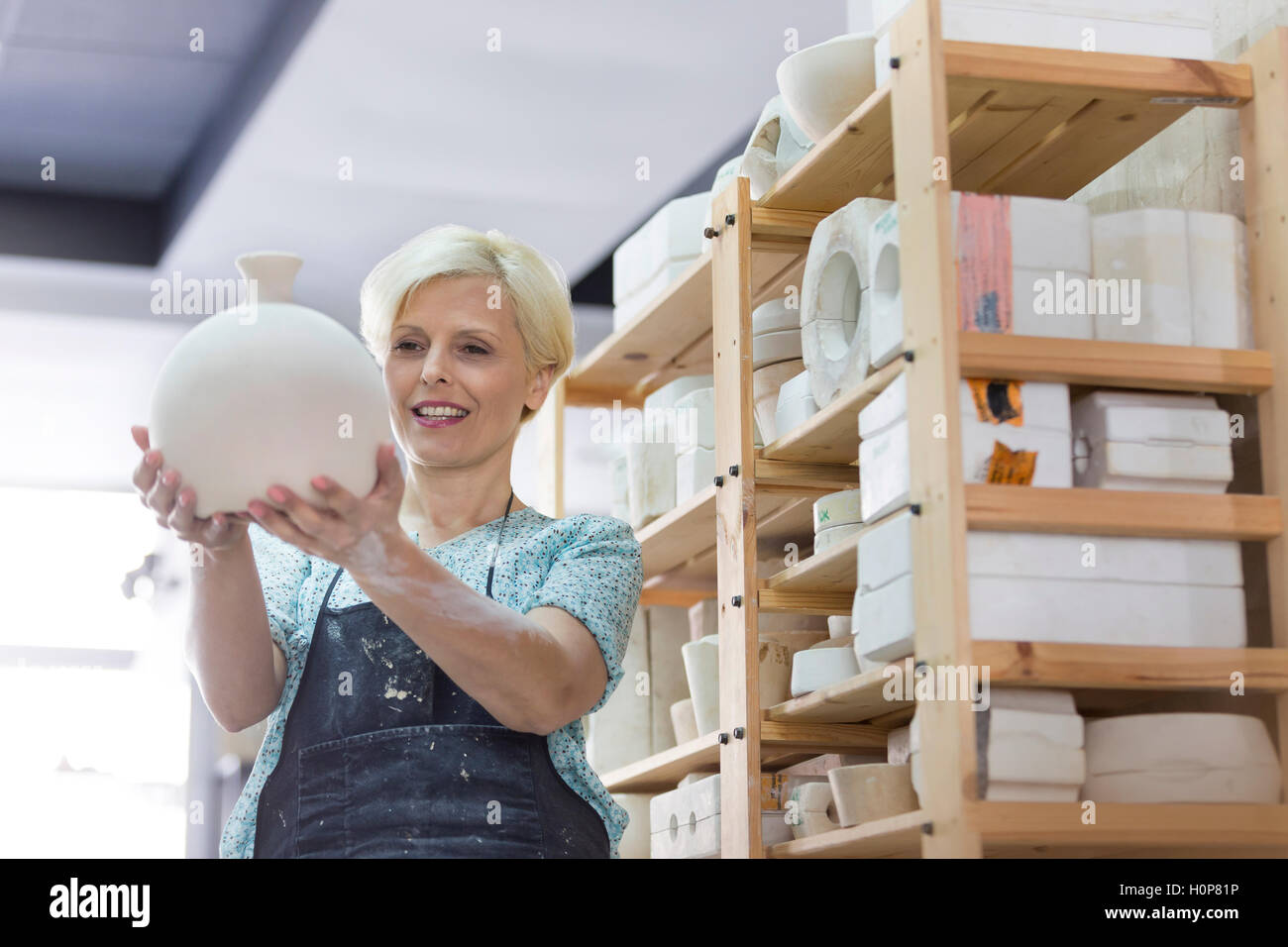 smiling woman holding pottery vase studio Stock Photo - Alamy