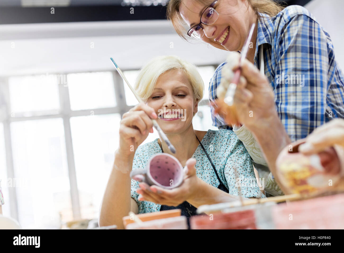 smiling mature woman painting pottery studio Stock Photo - Alamy