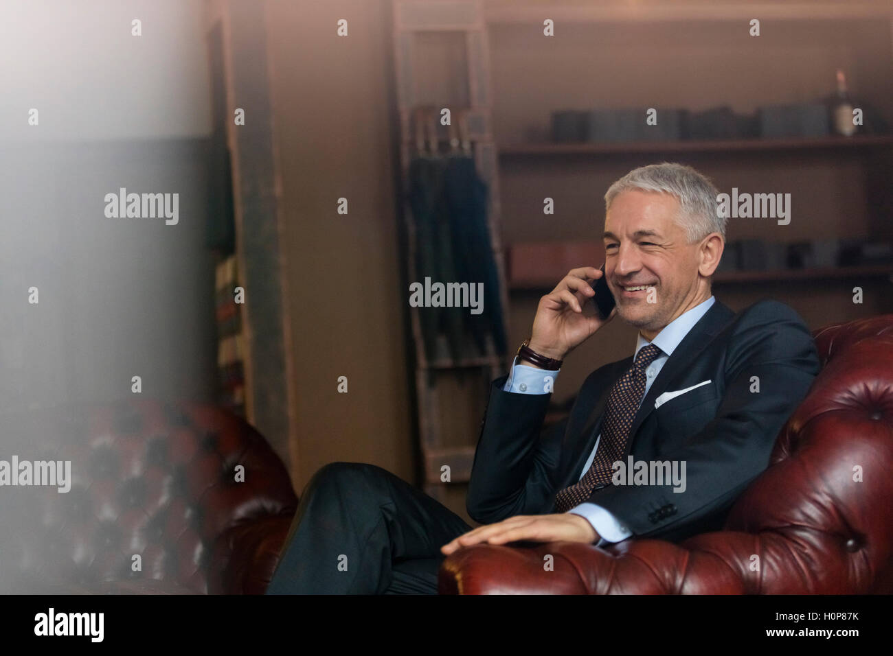 smiling businessman cell phone menswear shop Stock Photo