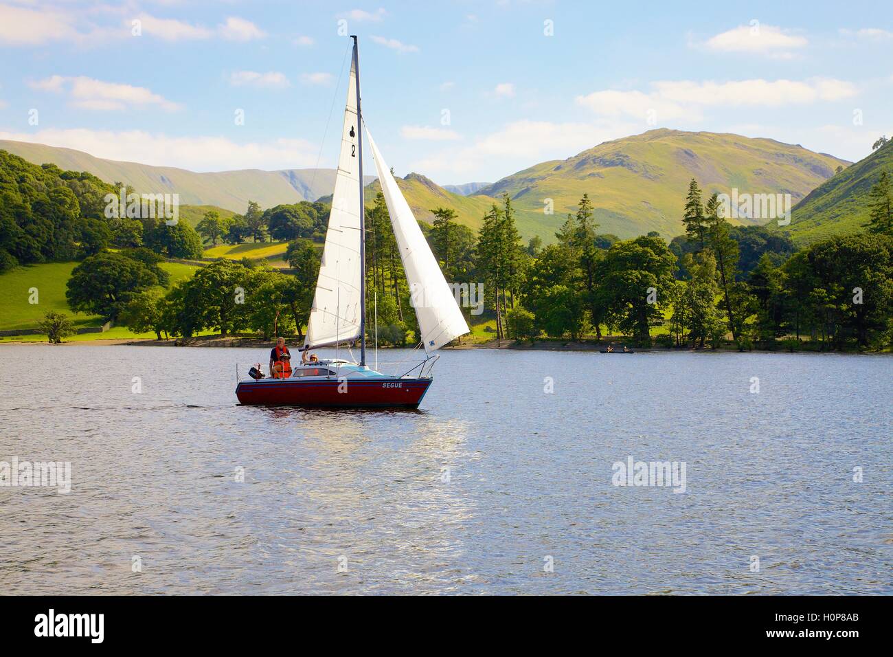 White sailed boat sailing. Sandwick Bay, Ullswater, Penrith, The Lake District National Park, Cumbria, England, United Kingdom. Stock Photo