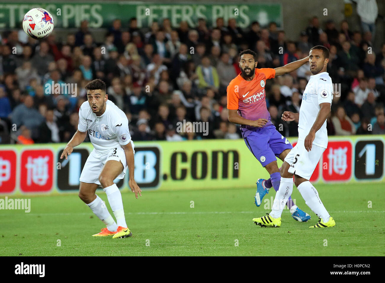 Swansea City S Neil Taylor Left And Wayne Routledge Right Watch As Manchester City S Gael Clichy Takes A Shot During The Efl Cup Third Round Match At The Liberty Stadium Swansea Stock Photo