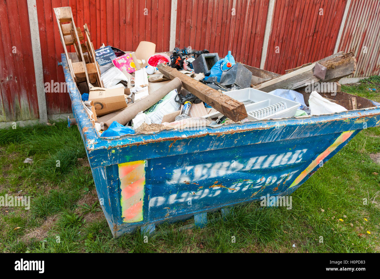 A blue metal Kershire skip full of rubbish and scrap Stock Photo