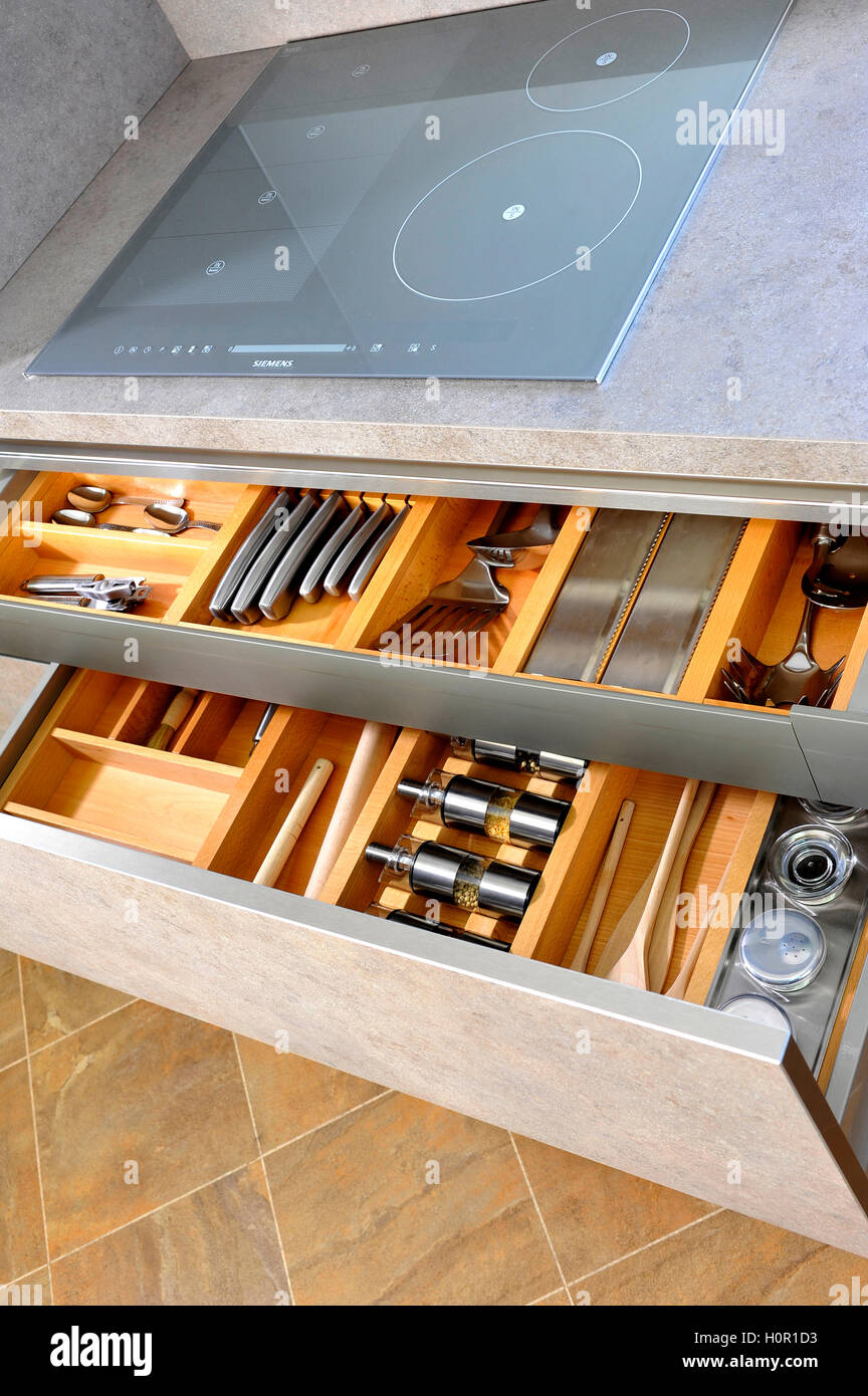 Two organised and tidy modern kitchen drawer interiors with utensils and knives Stock Photo
