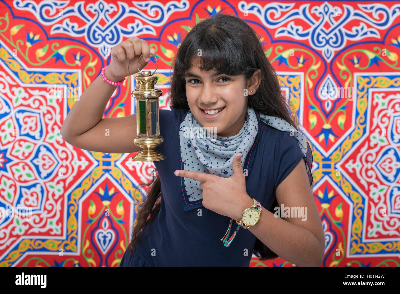 Happy Beauty Girl with Lantern Celebrating Ramadan over Ramadan Fabric Stock Photo