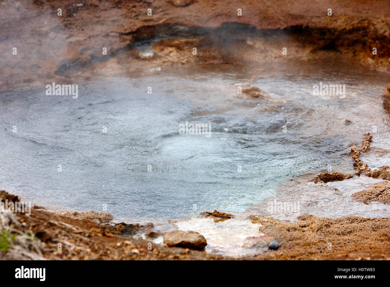 water boiling and steam rising in a hot springs geyser geysir Iceland Stock Photo