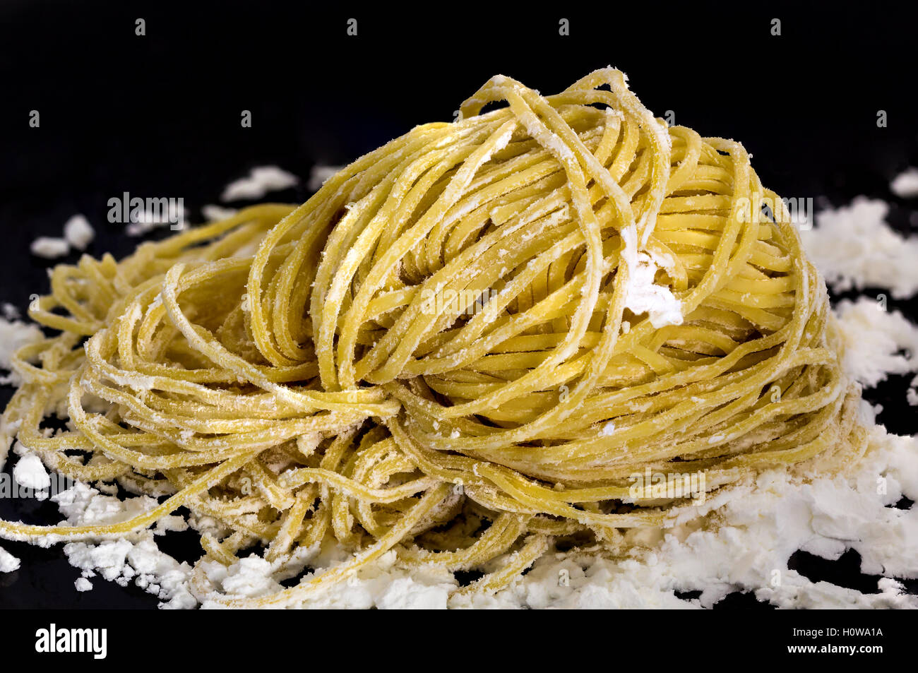 Closeup yellow Chinese egg noodle on dark background Stock Photo
