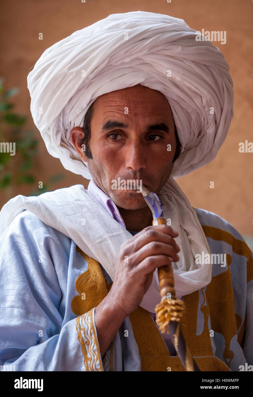 Near Ait Oudinar, Dades Gorge, Morocco.  Young Berber Man Smoking a Water Pipe. Stock Photo