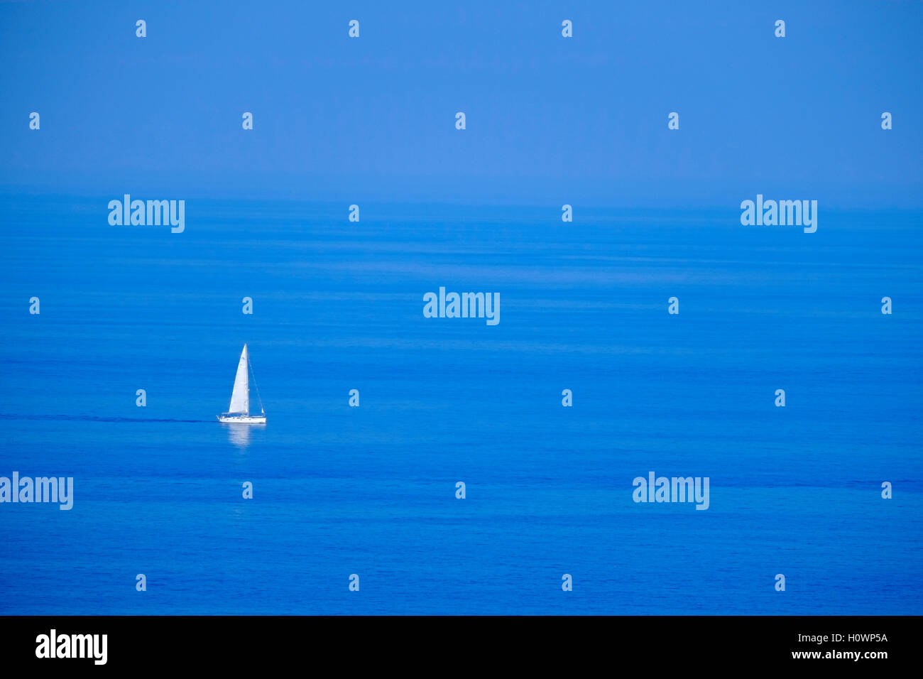 White sailing boat on deep blue sea Stock Photo - Alamy