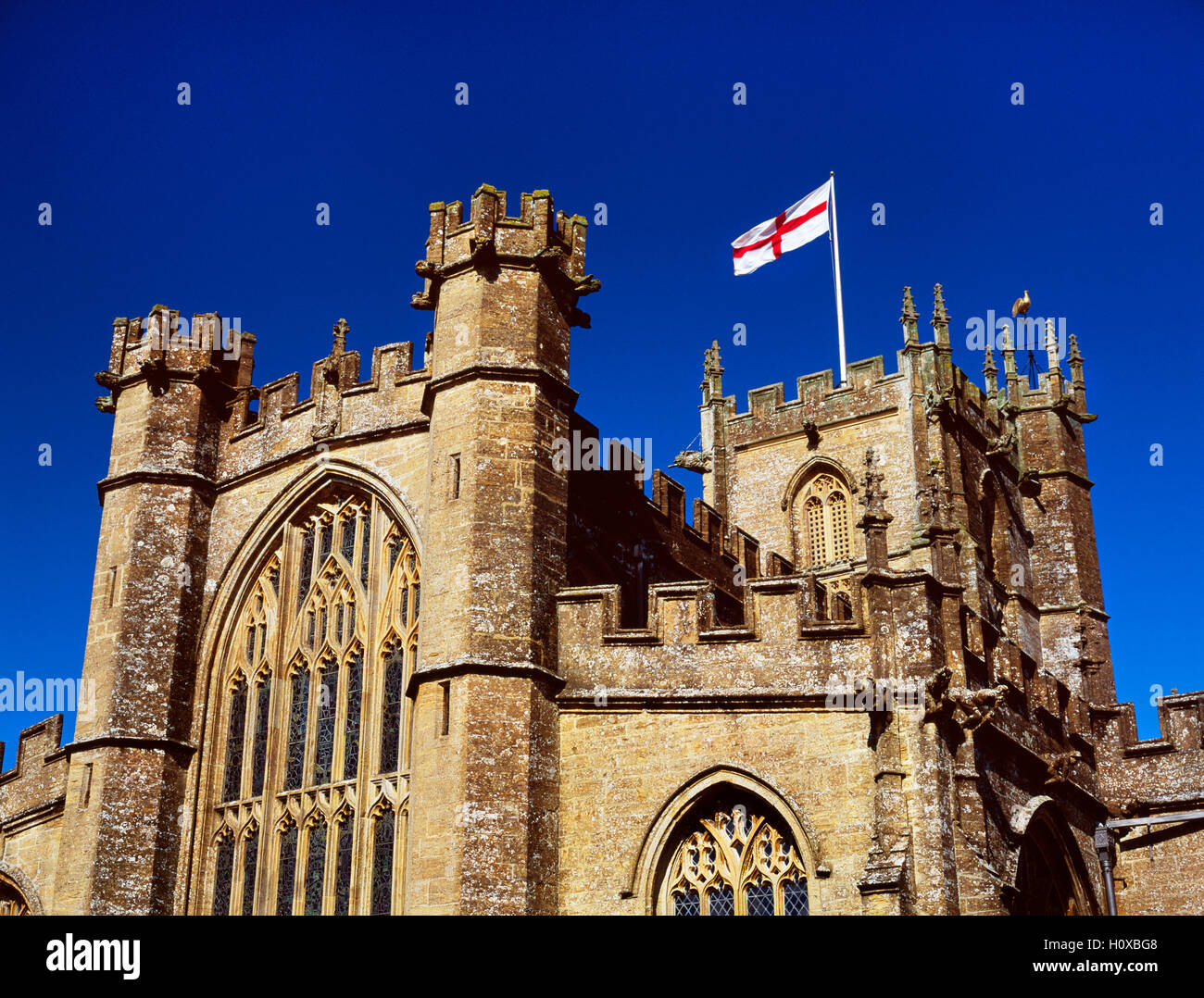 The Flag of St George, also known as the English Flag, flying from the central tower St Bartholomew's church, Crewkerne, Somerset, England, UK. Stock Photo