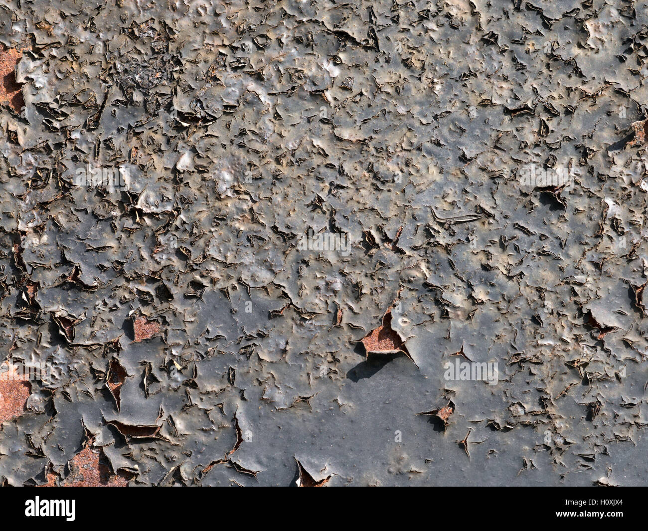 Black peeling paint on a rusty surface. close up texture detail. Stock Photo