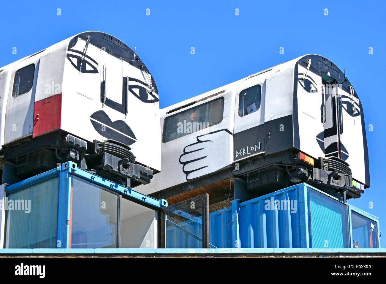 'Village Underground' recycled tube train carriages used as affordable artists studios perched on old shipping containers Shoreditch London England UK Stock Photo