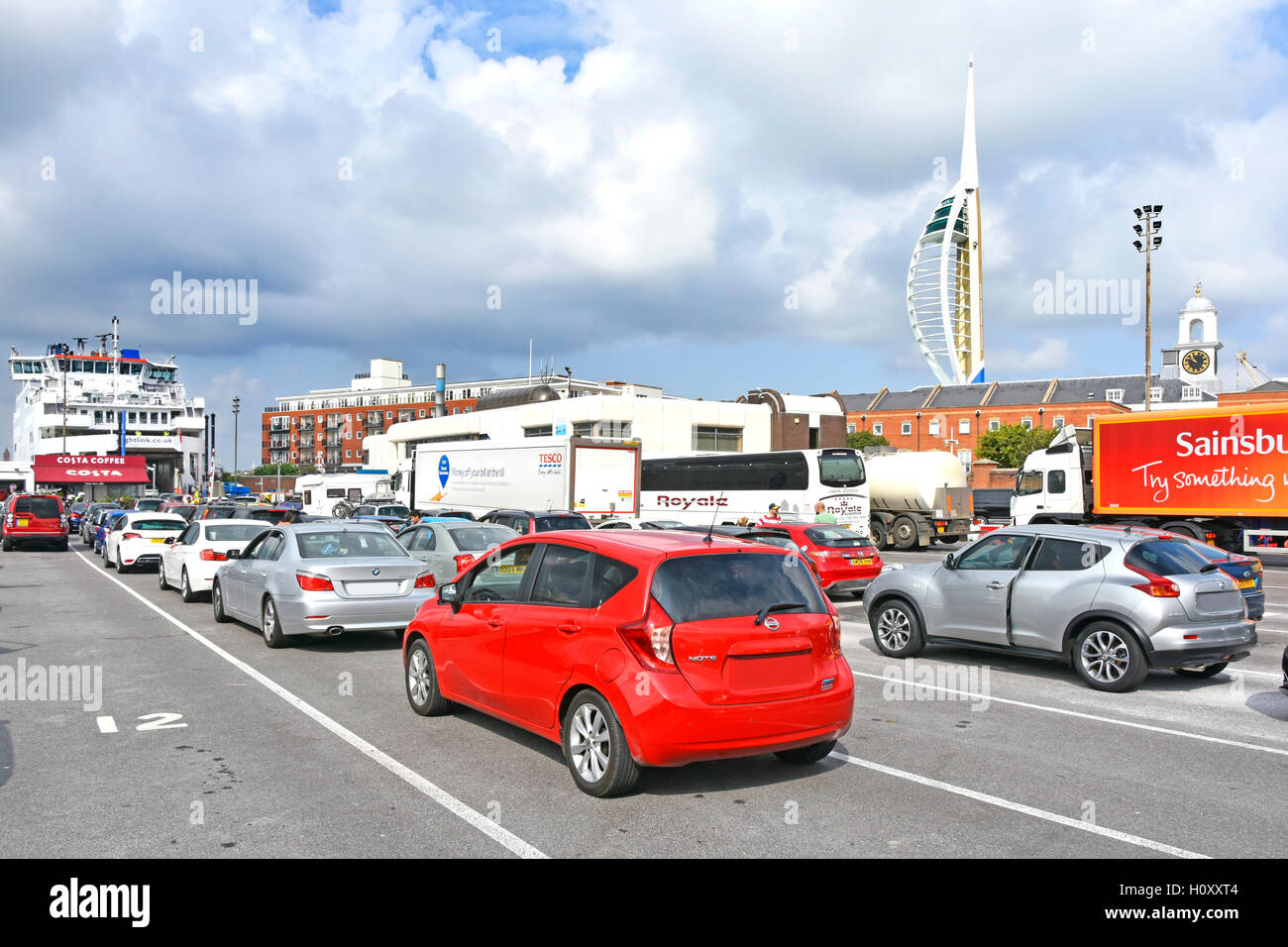 Cars lorries & coach queuing to board Wightlink summer ferry crossing Solent to Fishbourne on the Isle of Wight England UK some obscured number plates Stock Photo