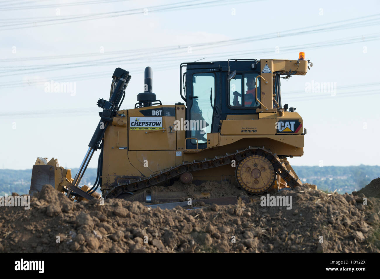 Bulldozer pushing mud over to create a wall around a new mine. Stock Photo