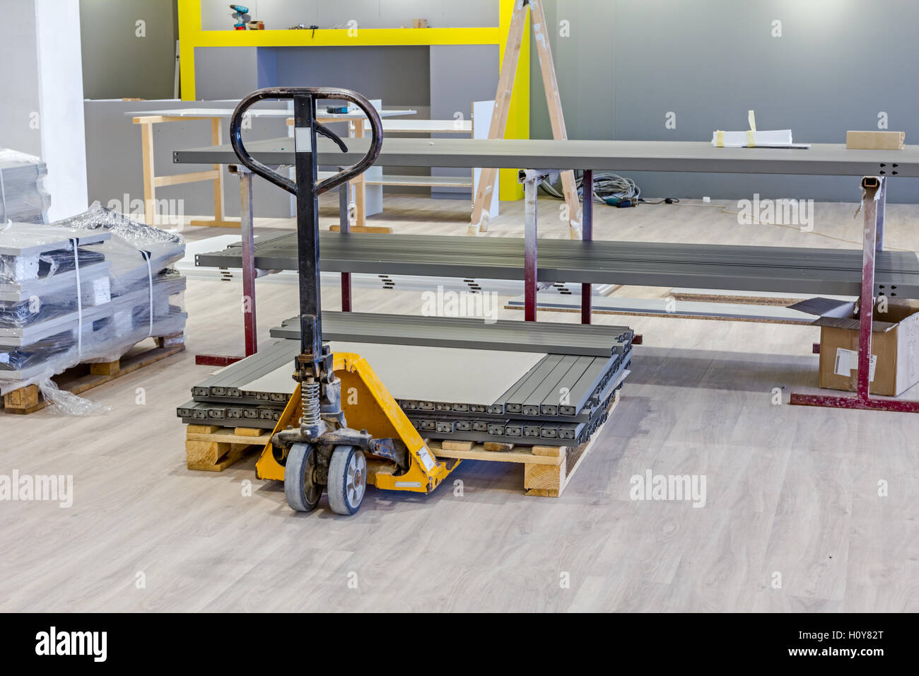 Yellow plastic crates, pallet jack, pedestrian stacker for transport