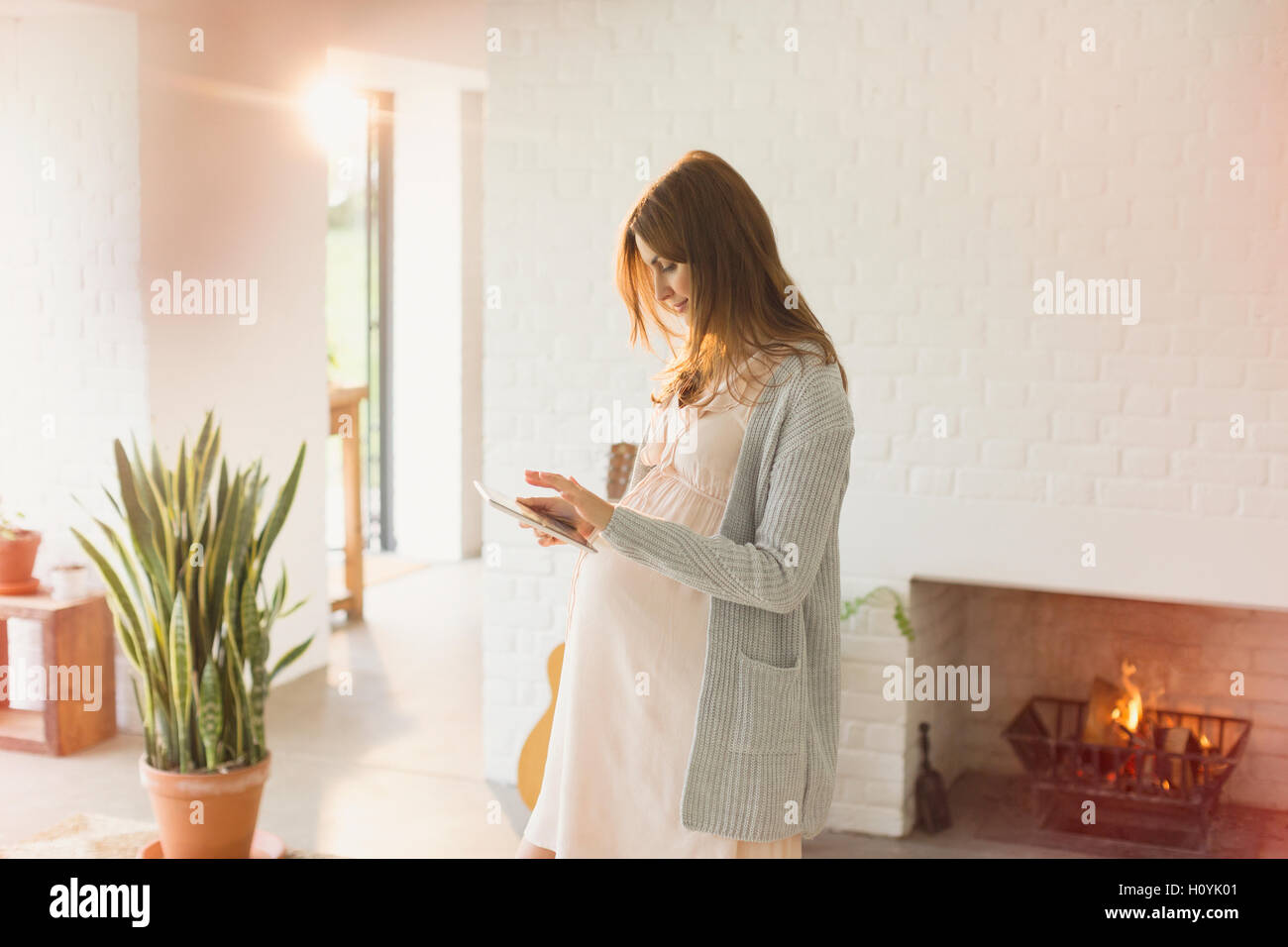pregnancy woman digital tablet fireplace Stock Photo Alamy