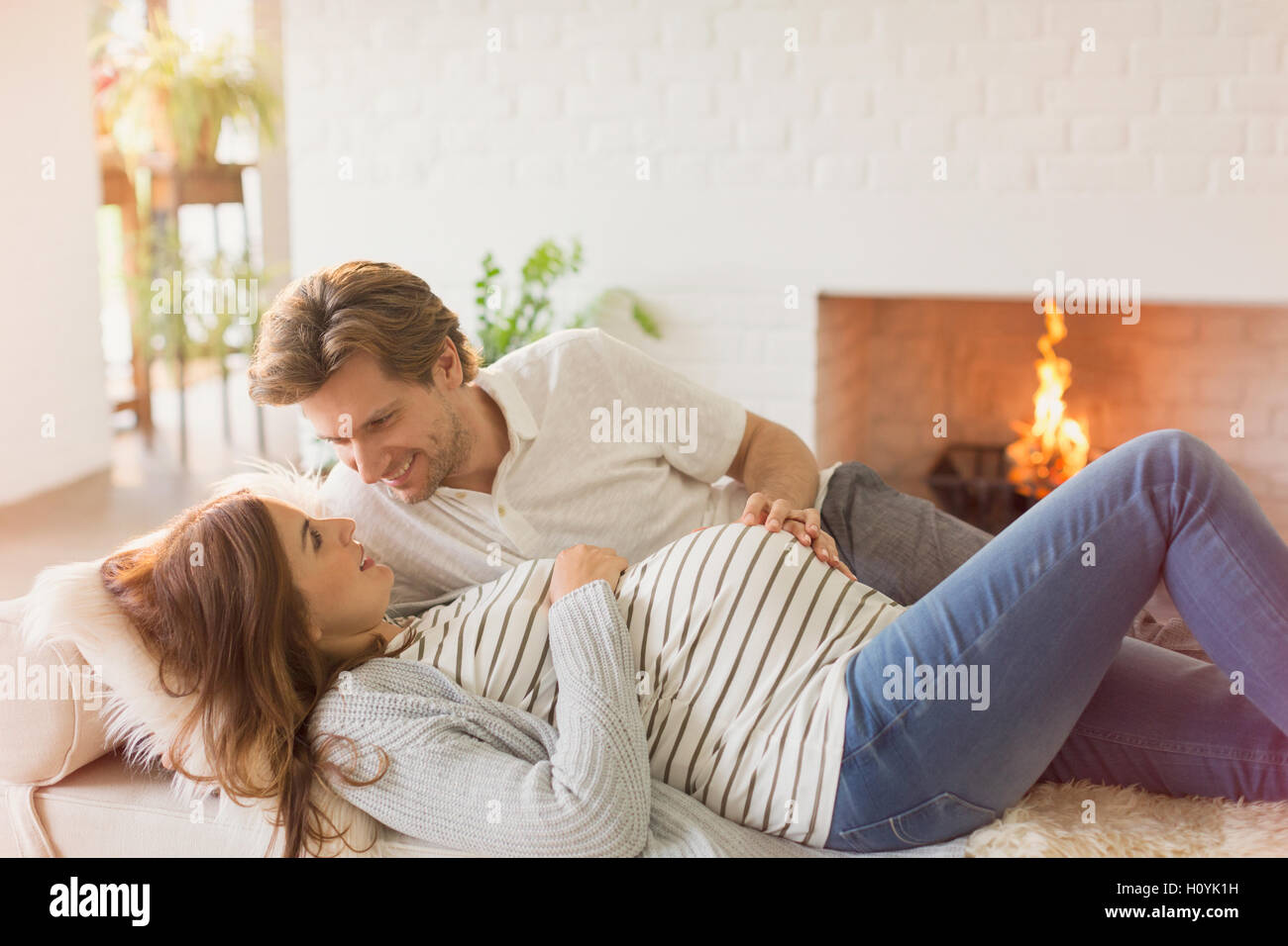 pregnancy couple laying fireplace living room Stock Photo Alamy