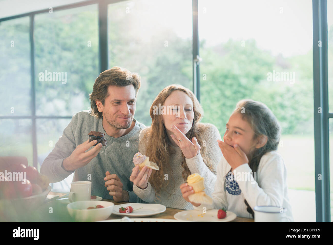 family eating cupcake table Stock Photo